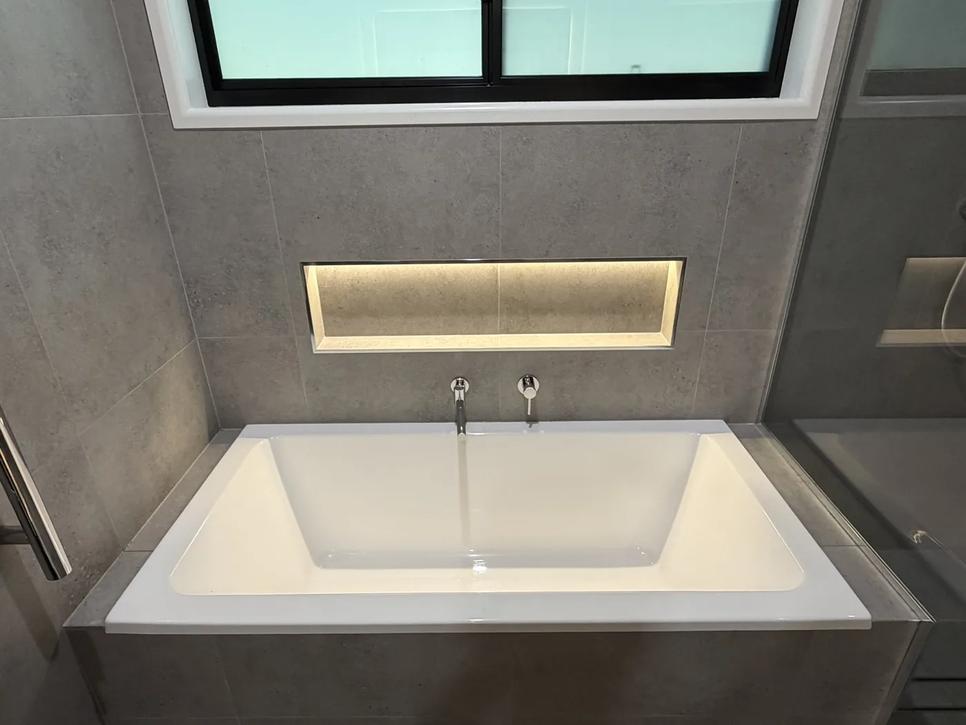 Clean bath area with window and feature wall